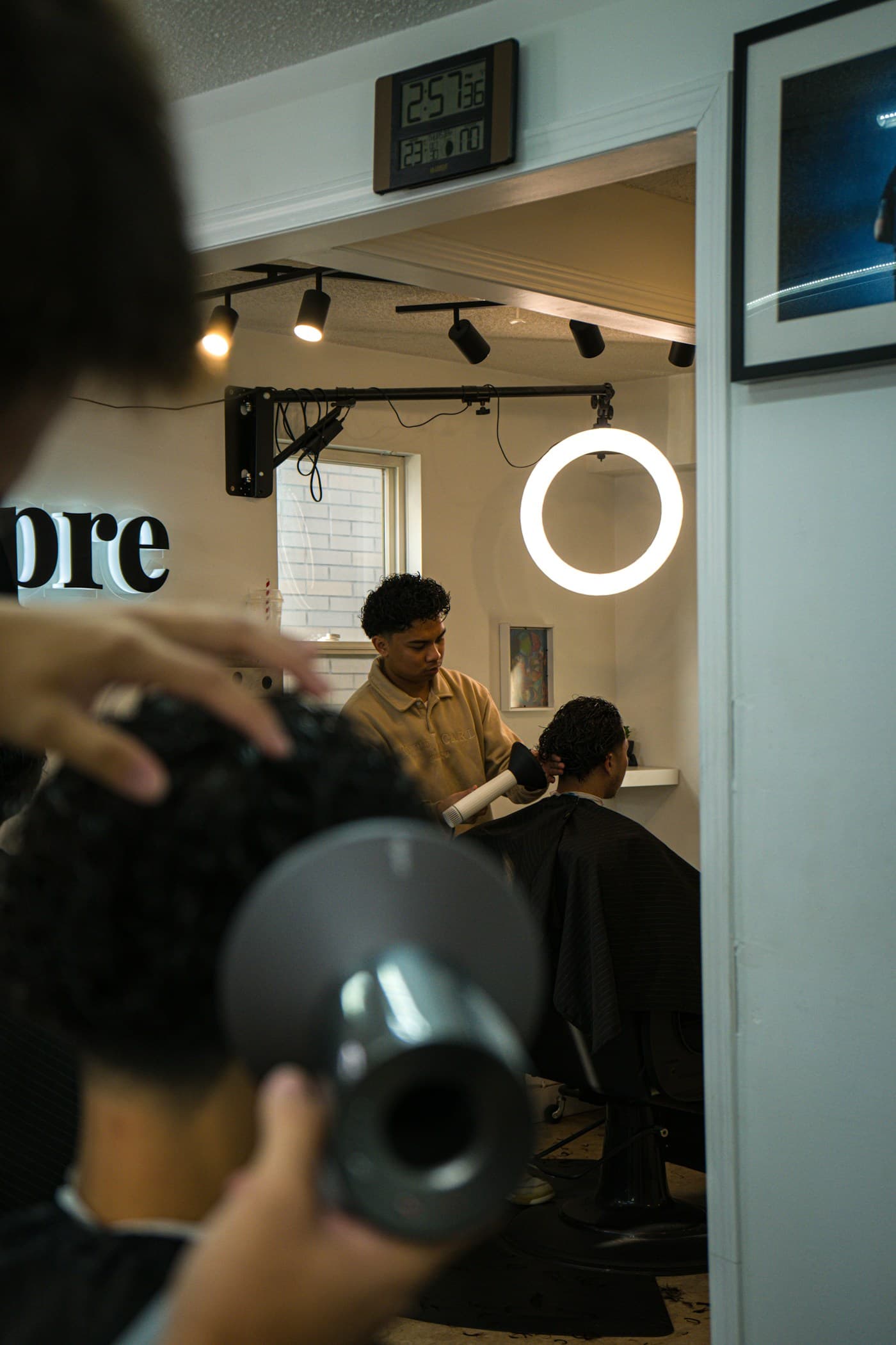 Stylist finishing a curly cut under the ring light